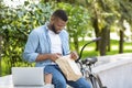 Lunch In Park. Black Guy Eating And Resting Outdoors With Laptop Royalty Free Stock Photo