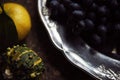 Lunch Provencal style still life on wooden table, flower pattern, seasonal vegetables, wine grapes, pumpkin, daylight. Royalty Free Stock Photo