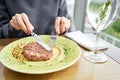 Lunch in a restaurant, a woman cuts delicious Beefsteak marbled beef, served with bulgur and smoked onion cream Royalty Free Stock Photo