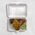 Lunch of rice with fried chicken called ayam penyet on a styrofoam container