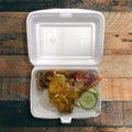 Lunch of rice with fried chicken called ayam penyet on a styrofoam container