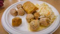 Lunch at a roadside cafe. Scrambled eggs, croquettes, meatballs, salad on a disposable paper plate Royalty Free Stock Photo