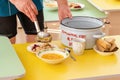 Lunch in a Russian kindergarten. The nurse lays out the food with a ladle from a saucepan with the inscription in Russian