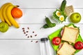 Lunch. Sandwich and fresh vegetables, bottle of water, nuts and fruits on white wooden background. Healthy eating Royalty Free Stock Photo