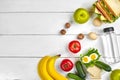 Lunch. Sandwich and fresh vegetables, bottle of water, nuts and fruits on white wooden background. Healthy eating Royalty Free Stock Photo
