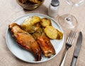 Lunch is served on plate - pieces of young rabbit baked with slice of potato. Close-up Royalty Free Stock Photo