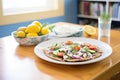 lunch setting: greek salad plate next to pita bread and tzatziki