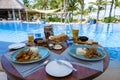 Lunch by a swimming pool during vacation in Mauritius, tropical setting with lunch drinks and curry by a pool Royalty Free Stock Photo