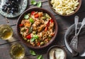 Lunch table. Roasted chicken with olives and sweet peppers, paste, white wine on dark background, top view. Royalty Free Stock Photo