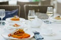 Lunch tablecloth with food and glasses of white wine with tea set