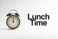 LUNCH TIME inscription written and alarm clock on white background Royalty Free Stock Photo