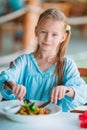 Adorable little girl having dinner at outdoor cafe Royalty Free Stock Photo