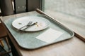 lunch tray with Empty dirty dish. White plate with fork and knife on table after dinner Royalty Free Stock Photo