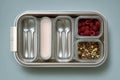 A lunchbox containing compartments with cutlery, yogurt, raspberries, and mixed nuts. The design is modern and practical for meal Royalty Free Stock Photo