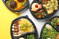 Lunchboxes with different meals on color table. Healthy food delivery