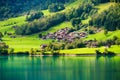 Lungern, canton of Obwalden, Switzerland. A view of rural homes in a green meadow. A lake in a mountain valley. Royalty Free Stock Photo