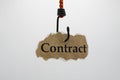Luring customers and unfair adhesion contract concept: isolated piece of brown old scrap paper hanging on hook, white background