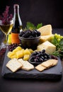 luscious Elderberry fruit set on a slate tray flanked by gourmet cheese crackers and an assortment of olives against a backdrop of