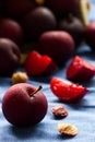 Luscious fresh Black Diamond plums grown in Portugal. Spilled from a paper bag onto blue cloth background. Royalty Free Stock Photo