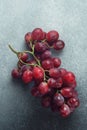 Luscious Red Grapes Bunch on a Coarse Textured Grey Surface Royalty Free Stock Photo