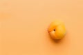 A lusciously ripe apricot rests tantalizingly atop a backdrop of soft, sun-kissed orange Royalty Free Stock Photo