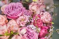 A lush bouquet of light pink, purple, orange cute delicate roses of different sizes, green white small flowers Royalty Free Stock Photo