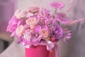 A lush bouquet of pink, purple, peach colour, white cute delicate small roses of different sizes, flowers in cylindrical box Royalty Free Stock Photo