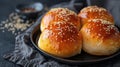 Lush buns with sesame seeds on a dark plate on a dark background Royalty Free Stock Photo