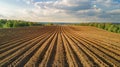 Lush green field freshly plowed with distinct visible furrows, primed for planting crops