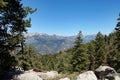 Distant mountain range framed by green forest and rocks Royalty Free Stock Photo