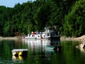 lush green river shore with small fishing boats and barge Royalty Free Stock Photo