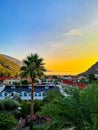 Lush mountaineous seaside town before sunset with paragliders