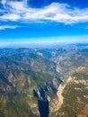 Lush mountaineous terrain with blue sky and clouds