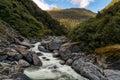 Lush native forest in Haast Pass in NZ with a powerful raging river flowing though the ravine