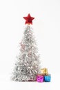 Lush silver Christmas tree decorated with a bright red star on the top Royalty Free Stock Photo