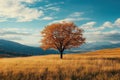 A lush, spreading tree in the middle of a field of dry grass against the backdrop of mountains. Generated by artificial Royalty Free Stock Photo