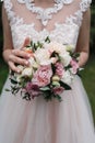 Lush wedding bouquet of white and pink peonies, roses.