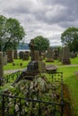 Luss, Scotland: A Grave Overgrown With Mosses And Topped With A Stone Cross