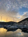 Lustica, Montenegro - 15 august 2023: Sunset behind the mountains over the marina with moored yachts Royalty Free Stock Photo