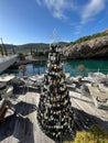 Lustica, Montenegro - 25 december 2022: Christmas tree made of wine bottles stands near tables with chairs on the Royalty Free Stock Photo