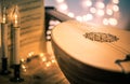 Lute with instrumental sheet music and soft lights for Christmas holiday, split tone Royalty Free Stock Photo