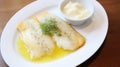 Lutefisk - Traditional Norwegian dish of dried fish rehydrated, on a white plate with melted butter Royalty Free Stock Photo