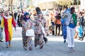 Smiling people with colorful costumes parading in the street