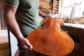 luthier attacching the front tables to the ribs of a cello in workshop
