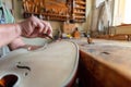 luthier carving the shape of the outside of the front of a violin with gouge Royalty Free Stock Photo