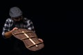 Luthier checking guitar back. Dark background