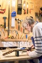 Luthier filing the frets of an acoustic guitar Royalty Free Stock Photo
