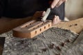 Luthier modifies the head of classical guitar. Royalty Free Stock Photo