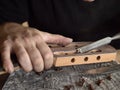 Luthier modifies the head of classical guitar. Royalty Free Stock Photo