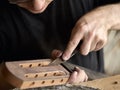 Luthier modifies the head of classical guitar. Royalty Free Stock Photo